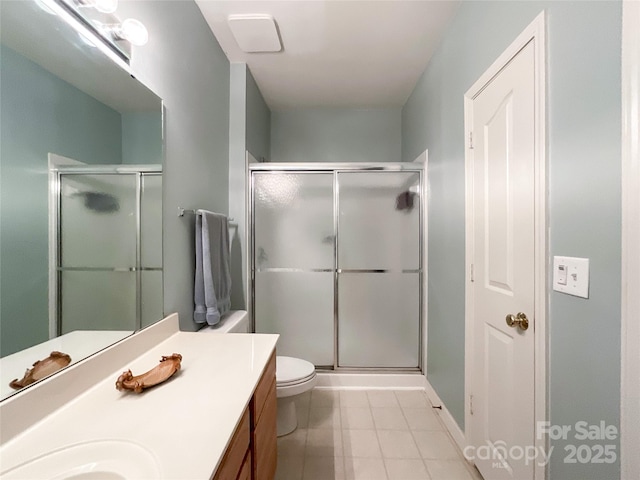 bathroom featuring vanity, a shower with door, and toilet