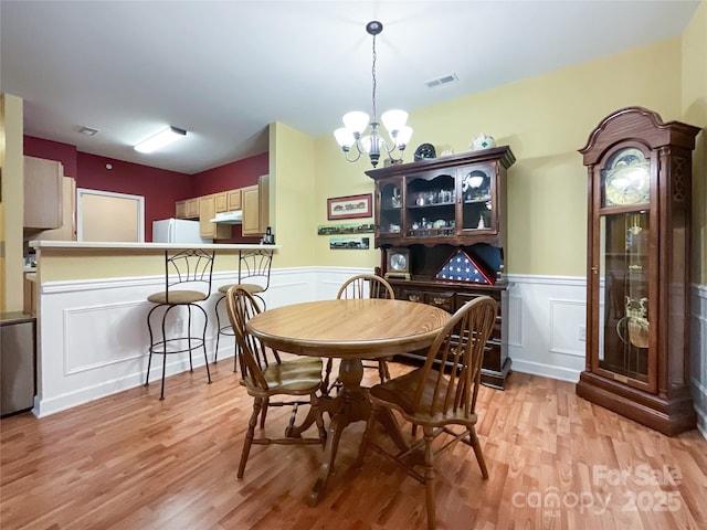 dining area featuring a notable chandelier and light hardwood / wood-style floors