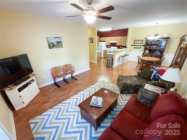 living room featuring hardwood / wood-style flooring and ceiling fan with notable chandelier