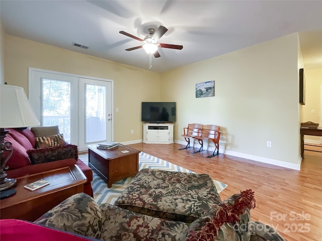 living room with light hardwood / wood-style flooring and ceiling fan