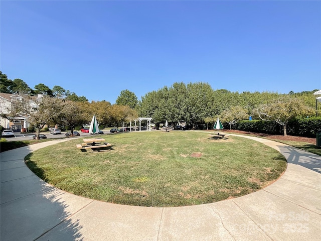 view of property's community with a pergola and a yard