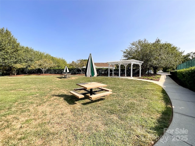 view of community featuring a yard and a pergola