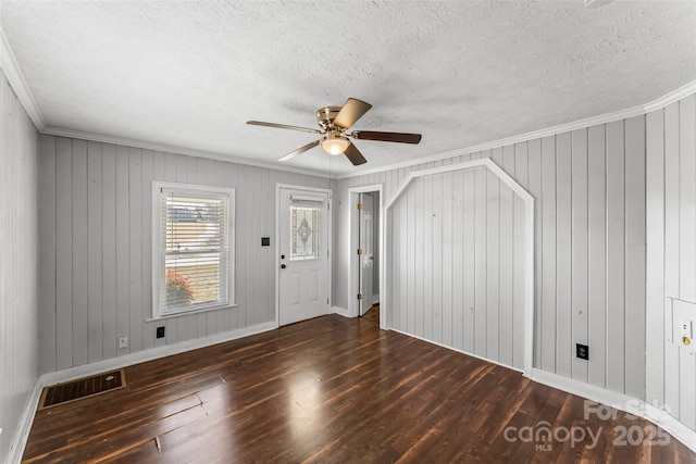 entryway featuring ornamental molding, dark hardwood / wood-style floors, and a textured ceiling