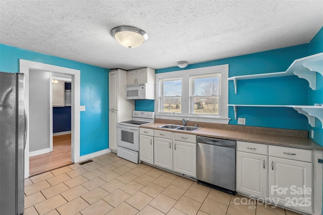 kitchen featuring white cabinetry, sink, a textured ceiling, and appliances with stainless steel finishes