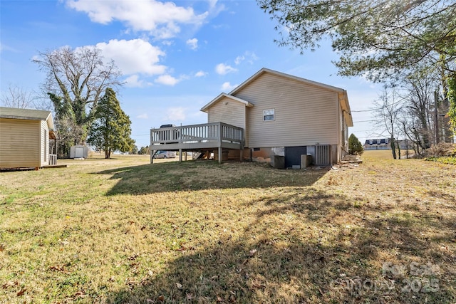 rear view of house featuring a shed, a yard, and a deck