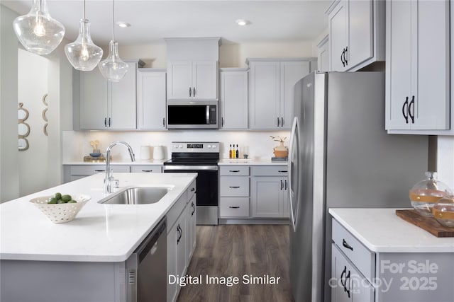 kitchen featuring sink, gray cabinets, pendant lighting, stainless steel appliances, and a kitchen island with sink