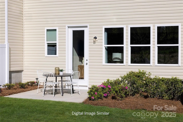 property entrance with a patio and a lawn