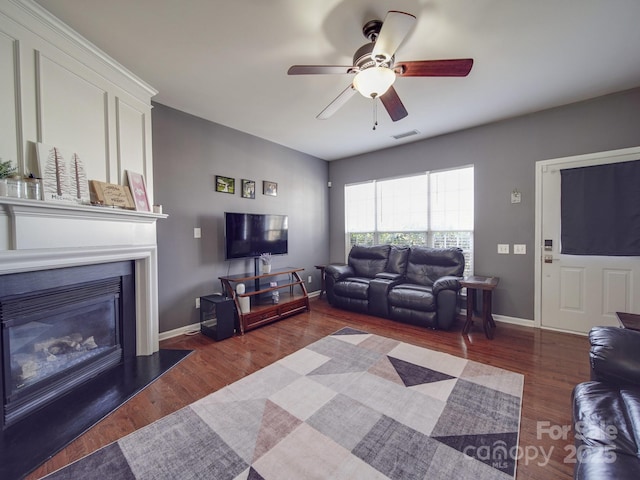 living room featuring ceiling fan and dark hardwood / wood-style flooring