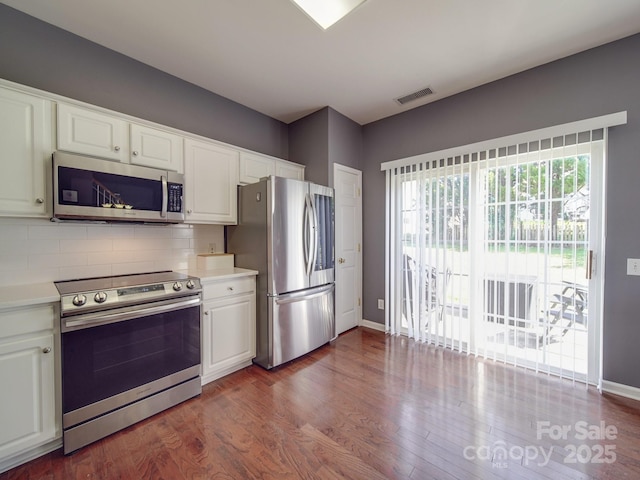 kitchen with stainless steel appliances, white cabinetry, dark hardwood / wood-style floors, and tasteful backsplash