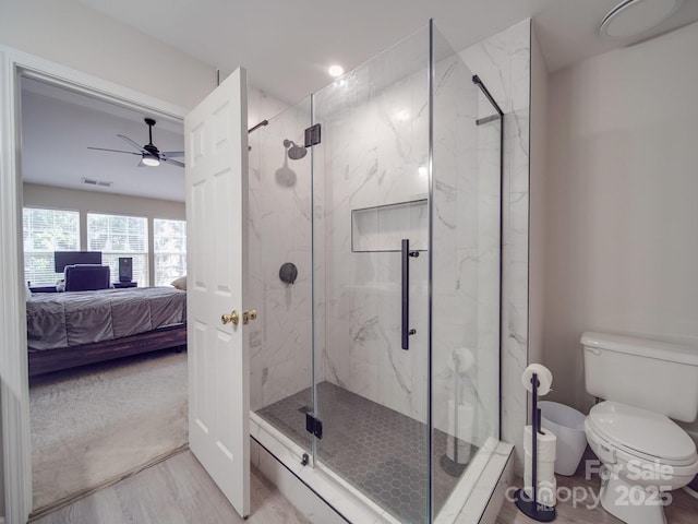 bathroom featuring an enclosed shower, ceiling fan, wood-type flooring, and toilet