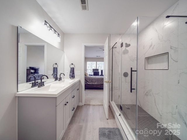 bathroom with hardwood / wood-style flooring, vanity, and a shower with shower door