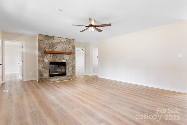 unfurnished living room with ceiling fan, a fireplace, and light hardwood / wood-style floors