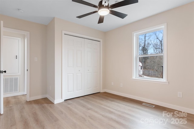 unfurnished bedroom featuring light hardwood / wood-style floors, a closet, and ceiling fan