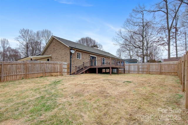 rear view of property with a yard and a deck