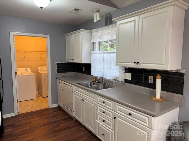 kitchen featuring sink, white cabinetry, white dishwasher, washing machine and dryer, and decorative backsplash