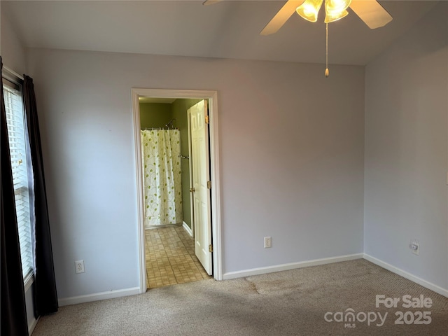 spare room with ceiling fan and light colored carpet