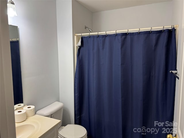 bathroom featuring vanity, toilet, and curtained shower