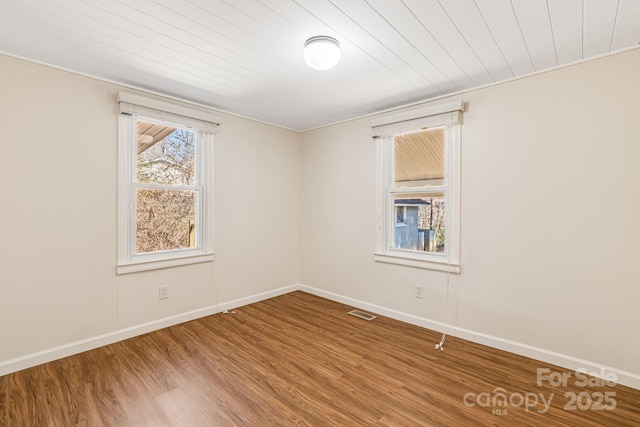 unfurnished room with wood ceiling, wood finished floors, visible vents, and baseboards