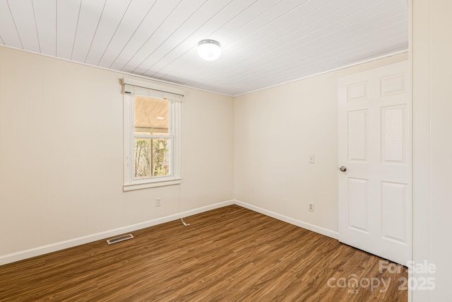 unfurnished room with wood ceiling, visible vents, baseboards, and wood finished floors