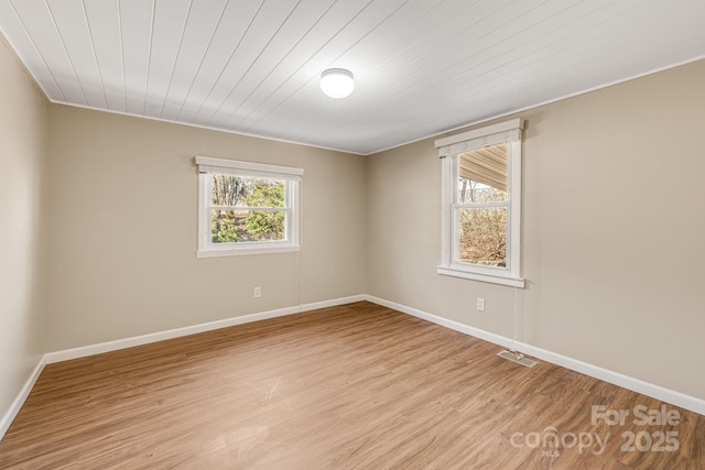 unfurnished room with a healthy amount of sunlight, light wood-style flooring, and baseboards