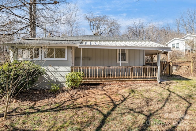 view of front of house with a carport, covered porch, and a front lawn