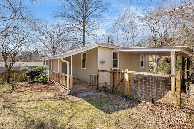 view of property exterior with driveway, an attached carport, and fence