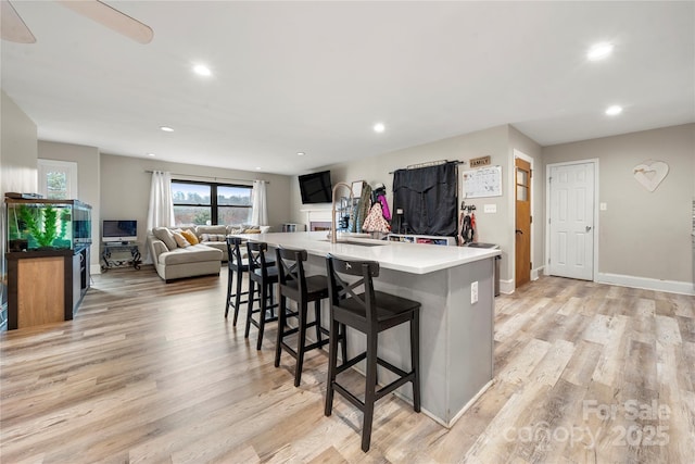 kitchen featuring light wood-type flooring, a kitchen breakfast bar, and a spacious island