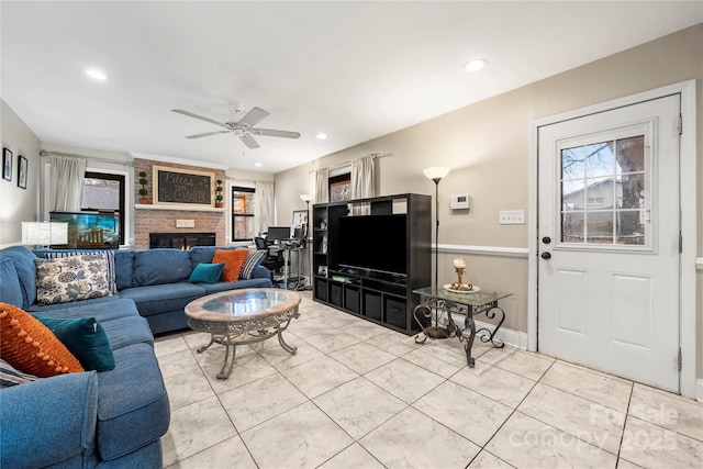 living room with a fireplace, plenty of natural light, ceiling fan, and light tile patterned flooring