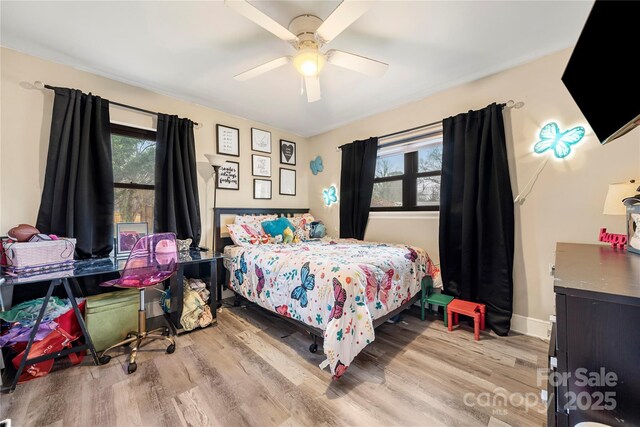 bedroom featuring multiple windows, ceiling fan, and light wood-type flooring