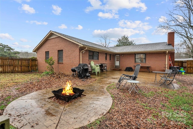 back of house featuring a patio area and a fire pit