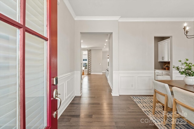 entrance foyer with ornamental molding and dark hardwood / wood-style floors