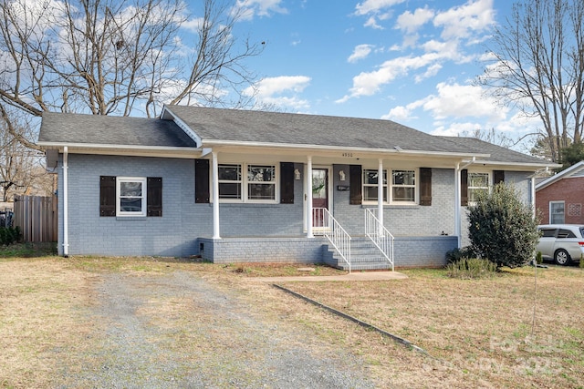 ranch-style house with a front yard and covered porch