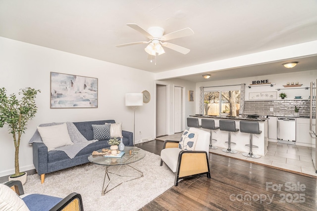 living room featuring dark wood-type flooring and ceiling fan