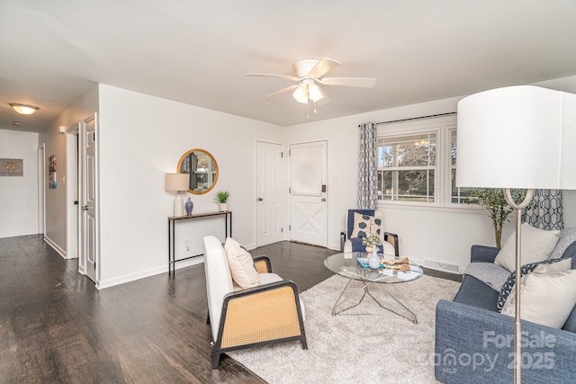 living room featuring visible vents, ceiling fan, baseboards, and wood finished floors