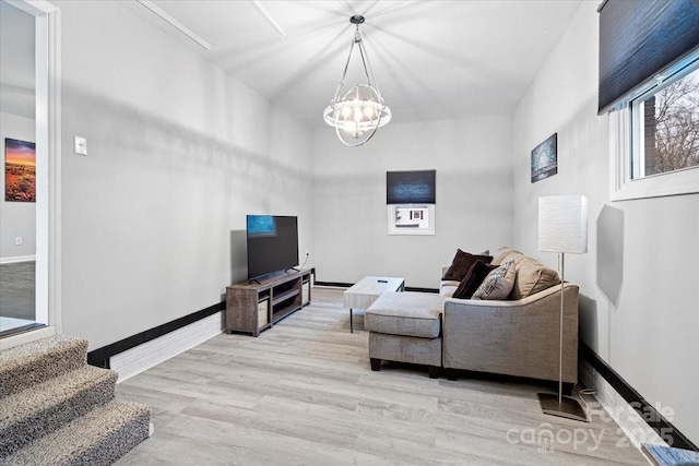 living room with an inviting chandelier and light hardwood / wood-style flooring