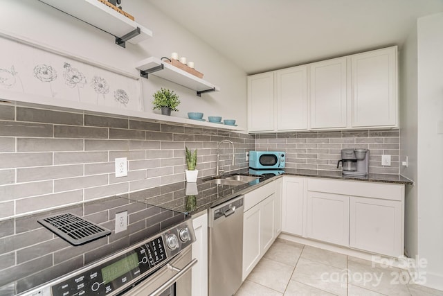 4930 Crestmont Dr, Charlotte, NC 28205 - kitchen with dark stone countertops, tasteful backsplash, white cabinets, a sink, and appliances with stainless steel finishes