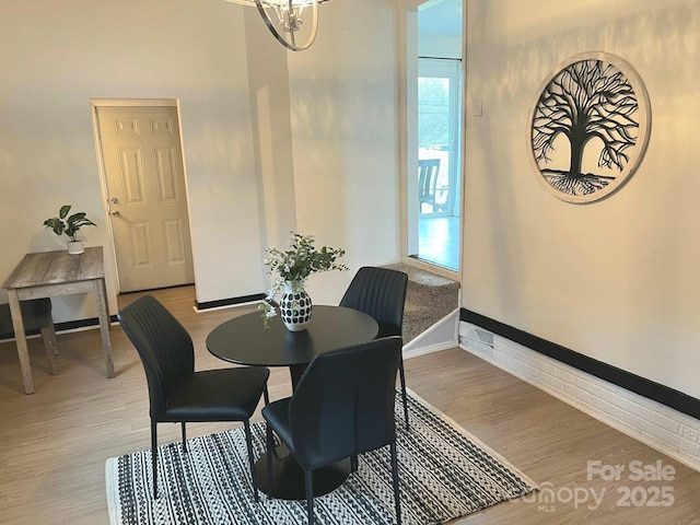 4930 Crestmont Dr, Charlotte, NC 28205 - dining room featuring baseboards, wood finished floors, and a notable chandelier