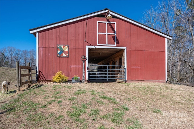 view of barn featuring fence