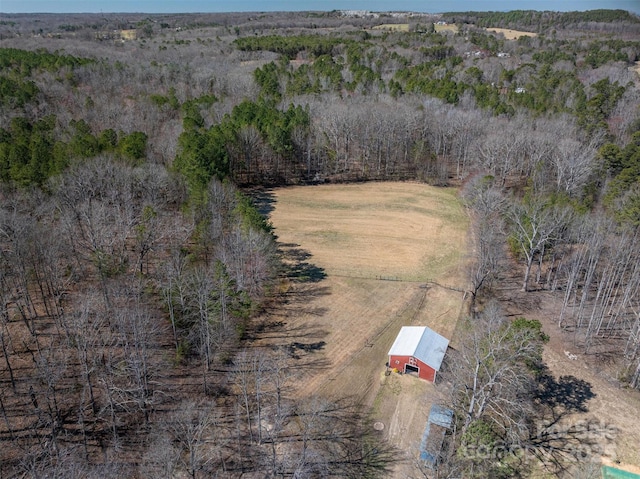 birds eye view of property with a view of trees and a rural view