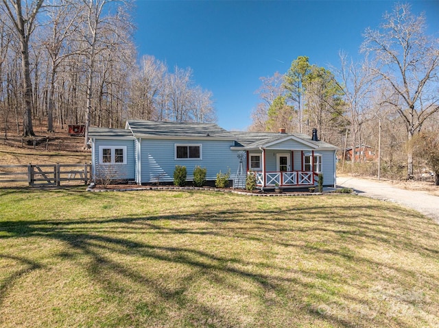 view of front of property with a porch, a front lawn, and fence