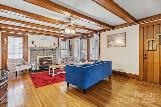 living room with hardwood / wood-style flooring, ceiling fan, and beam ceiling