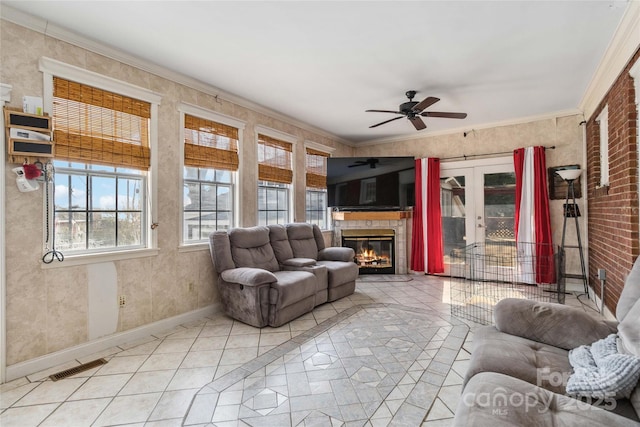 living room with ornamental molding, light tile patterned floors, and ceiling fan