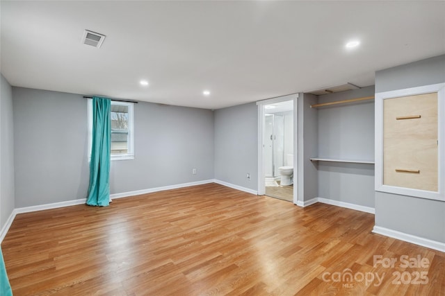 unfurnished bedroom with ensuite bath and light hardwood / wood-style floors