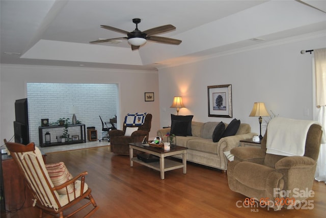 living room featuring crown molding, ceiling fan, wood-type flooring, and a tray ceiling