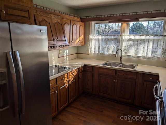 kitchen featuring sink, range, stainless steel fridge, dark hardwood / wood-style flooring, and black electric stovetop