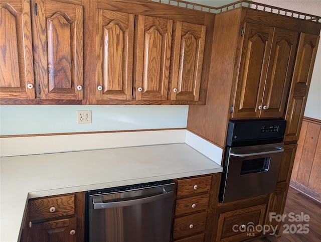 kitchen featuring stainless steel dishwasher, wood-type flooring, and oven