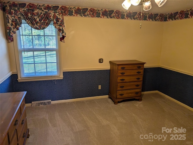 unfurnished bedroom featuring carpet flooring and a textured ceiling