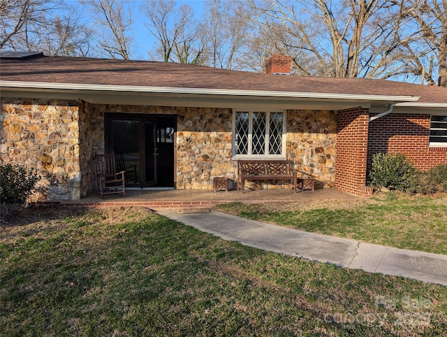 doorway to property featuring a lawn