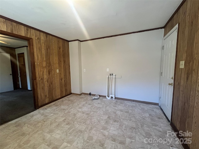 empty room featuring wooden walls and ornamental molding