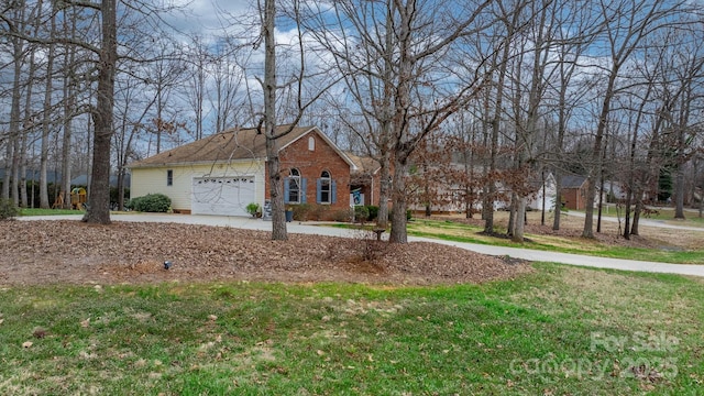 view of front of property featuring a garage, brick siding, driveway, and a front lawn